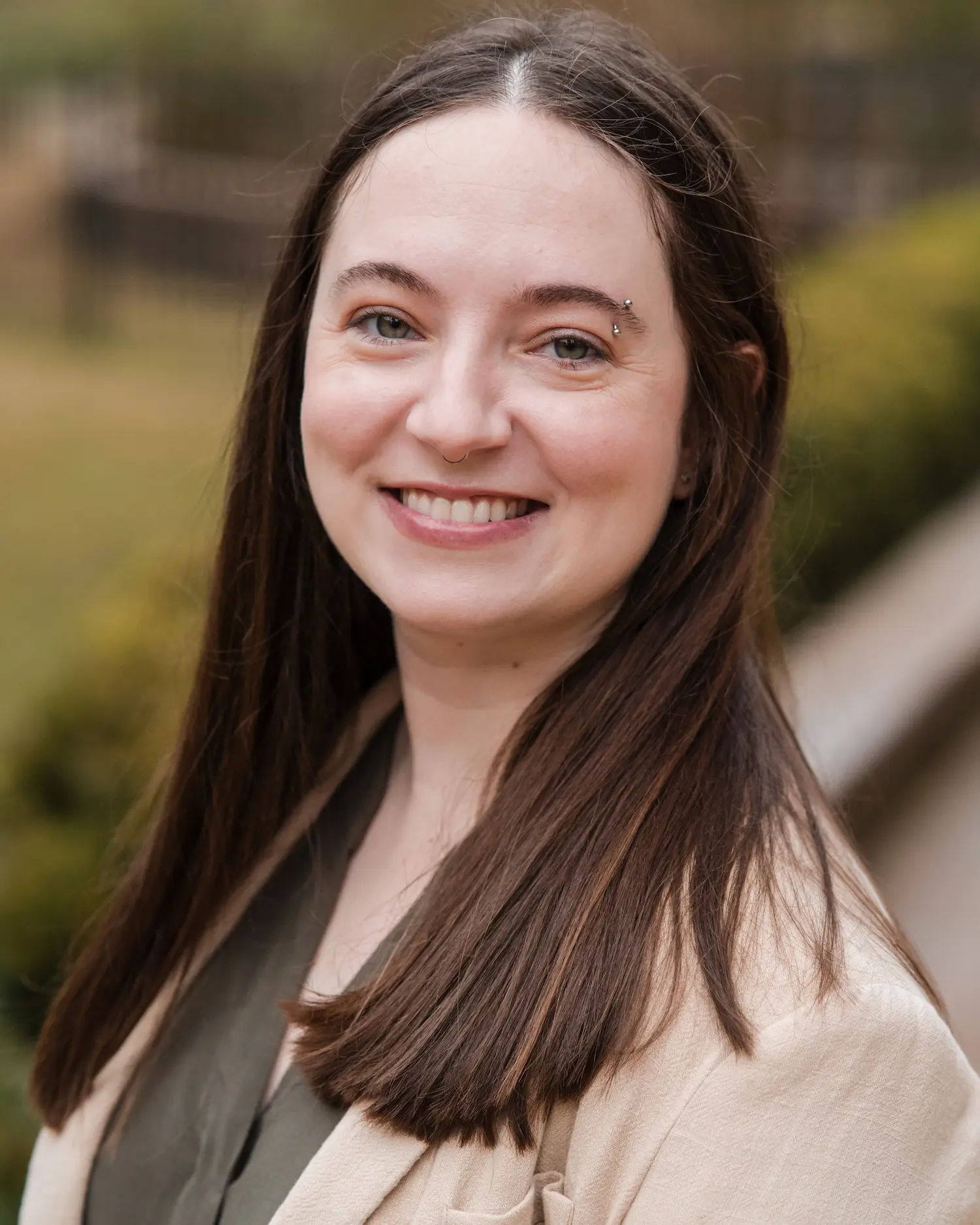 Woman smiling at camera outdoors in professional headshot